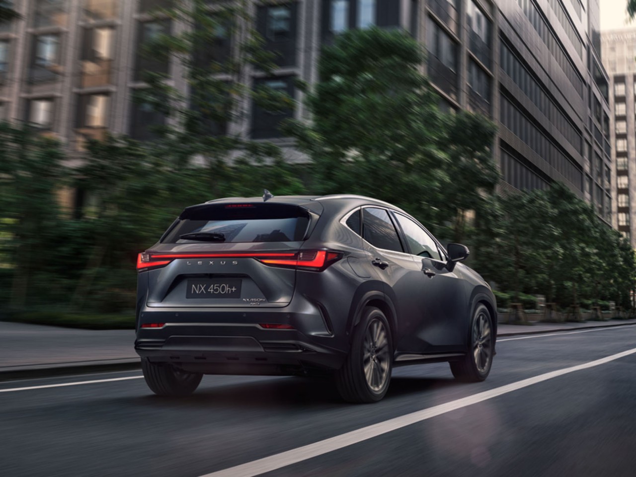 Rear view of the Lexus NX 450+ driving 